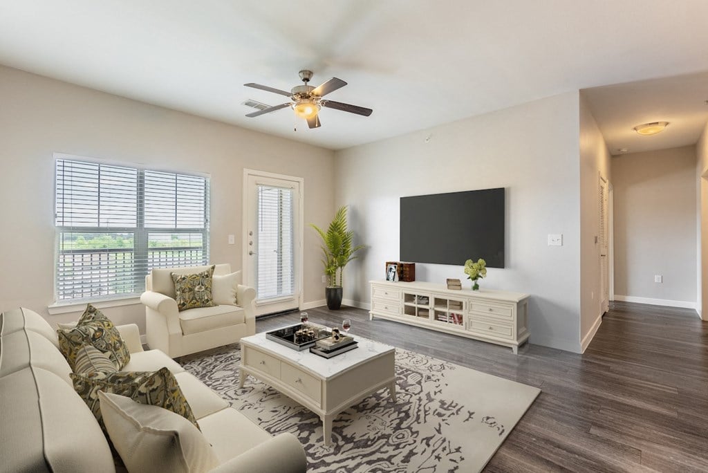a living room with a ceiling fan and a television