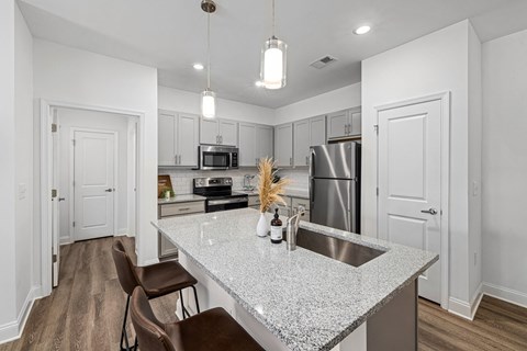 an open kitchen with granite counter top and stainless steel appliances