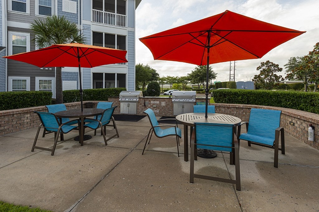 an outdoor patio with tables and chairs and umbrellas