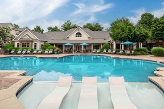 the preserve at ballantyne commons community swimming pool with lounge chairs and a house