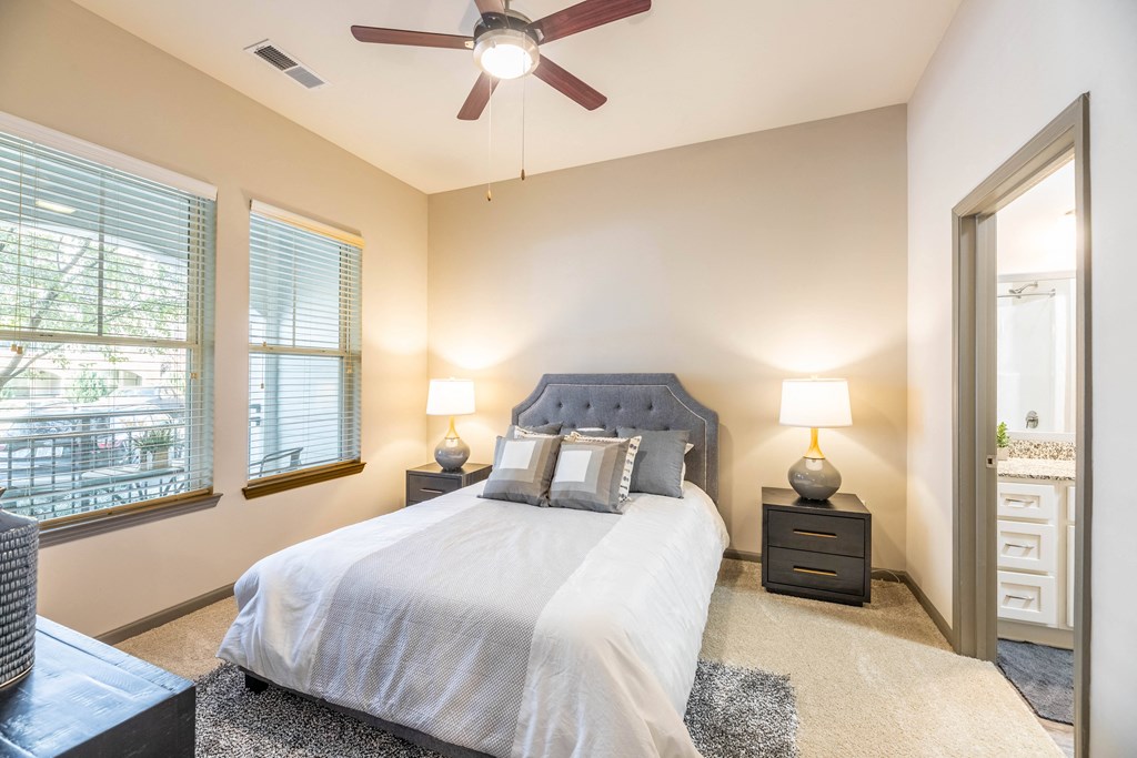 a bedroom with a large bed and a ceiling fan