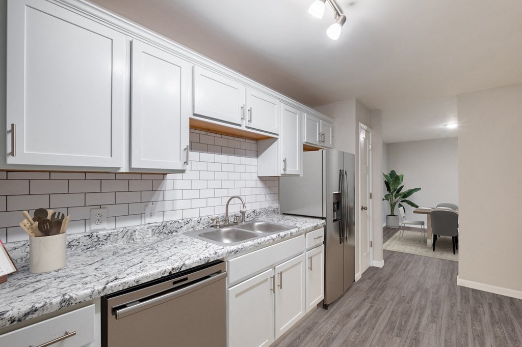 a kitchen with white cabinets and a granite countertop