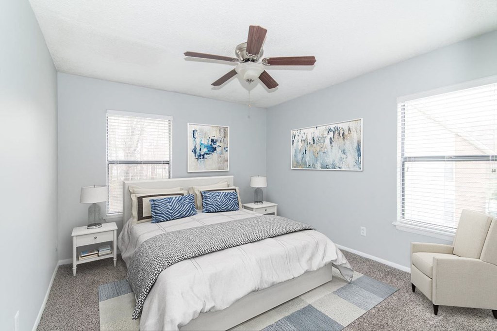 a bedroom with a bed and a ceiling fan
