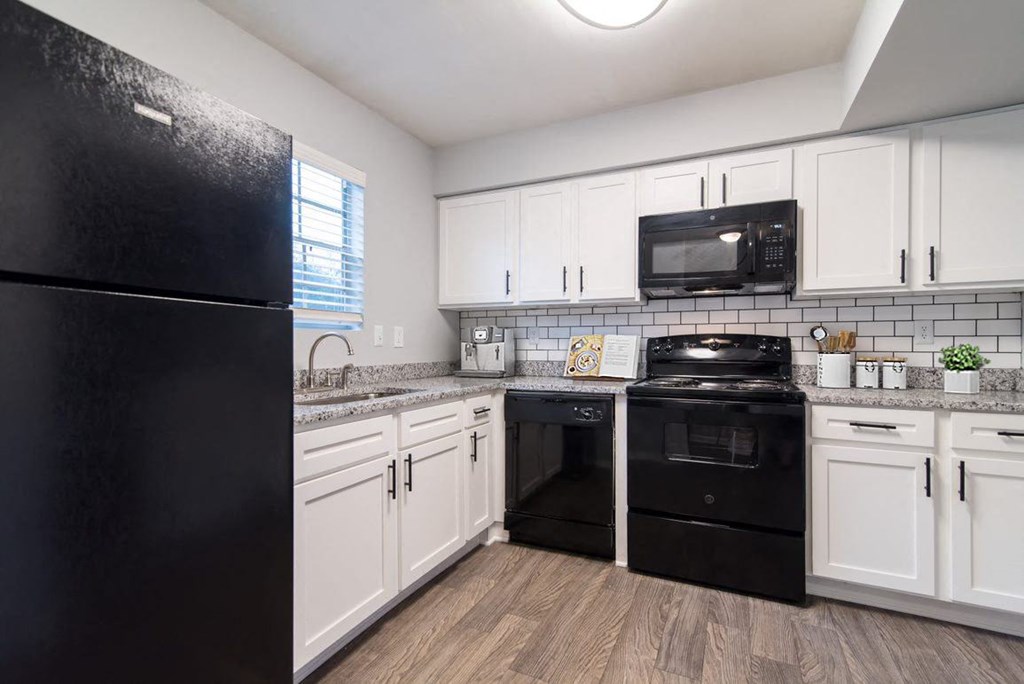 a kitchen with black appliances and white cabinets
