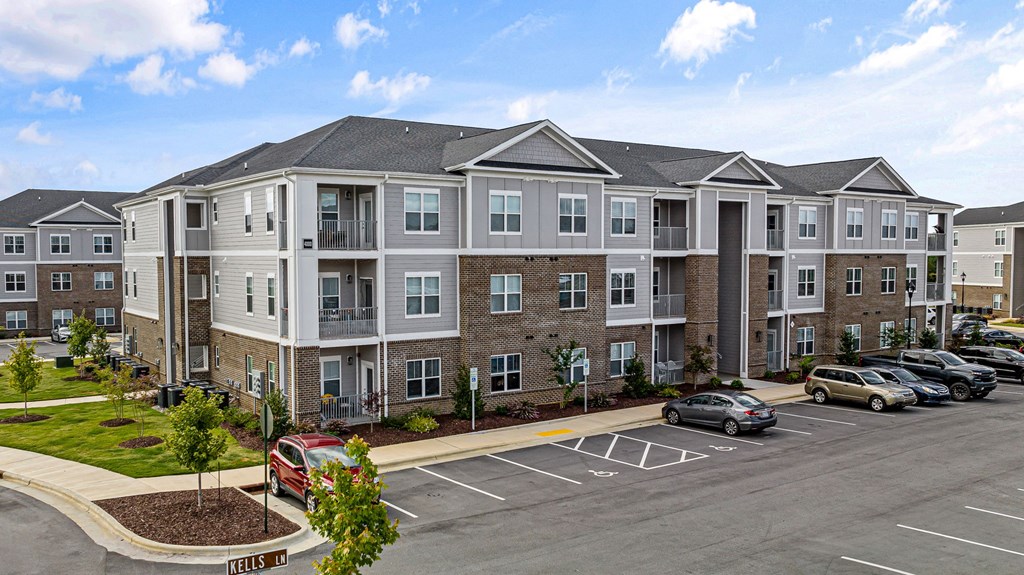 a large apartment building with cars parked in a parking lot