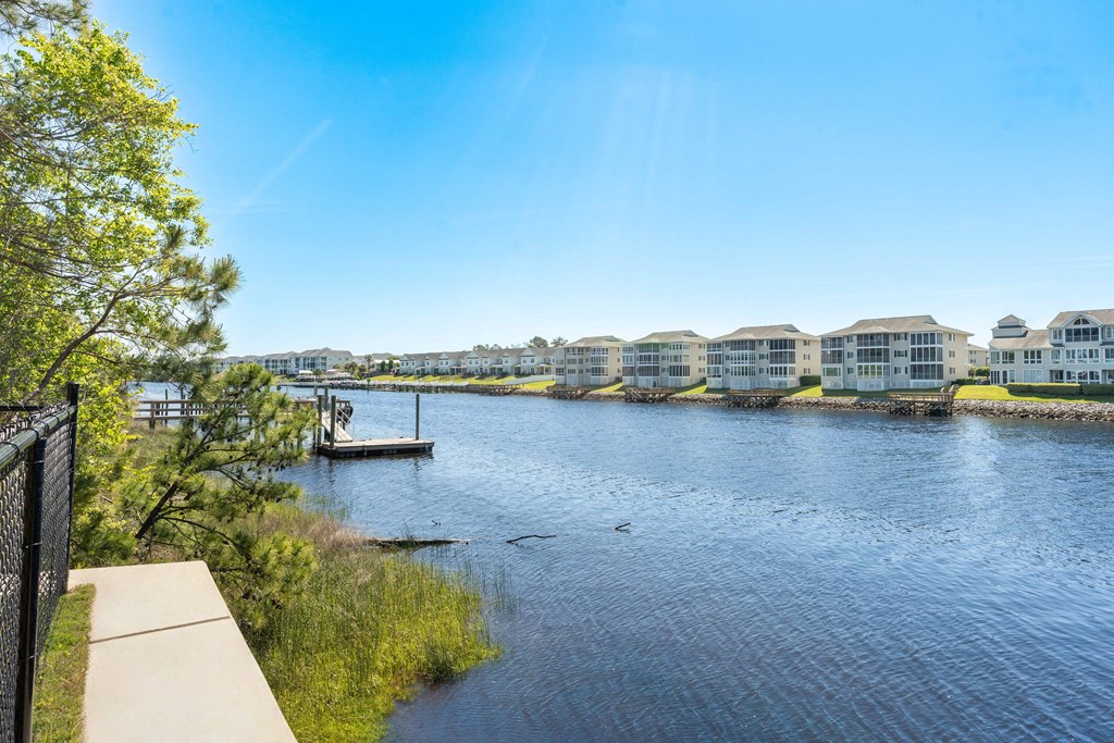 the view of a river with apartment buildings on the other side and a dock