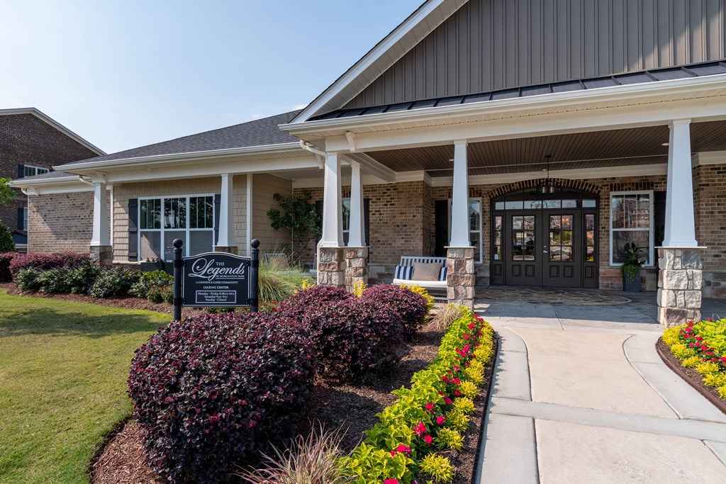 the front of a building with a bench and a sign in front of it