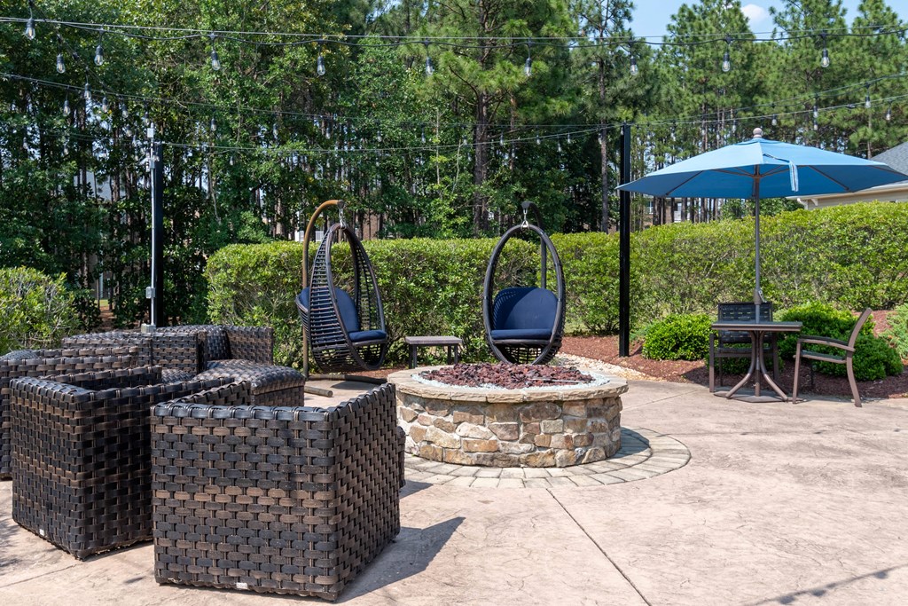 a patio with chairs and a fire pit