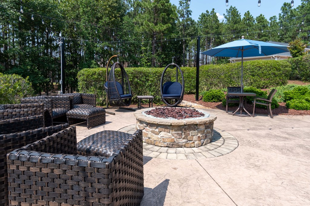 a patio with chairs and a fire pit