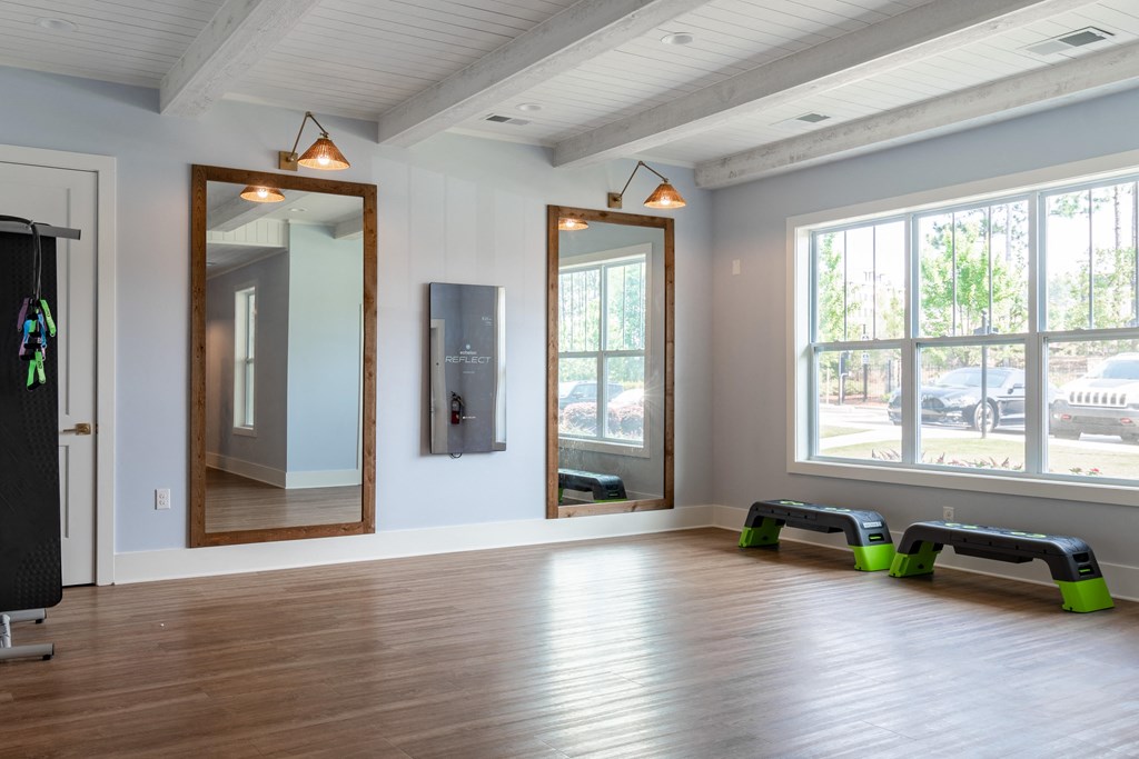 an empty room with a large window and two mirrors