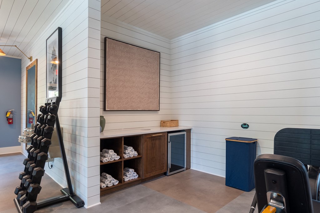 a gym with white walls and a wooden shelf with shoes on it