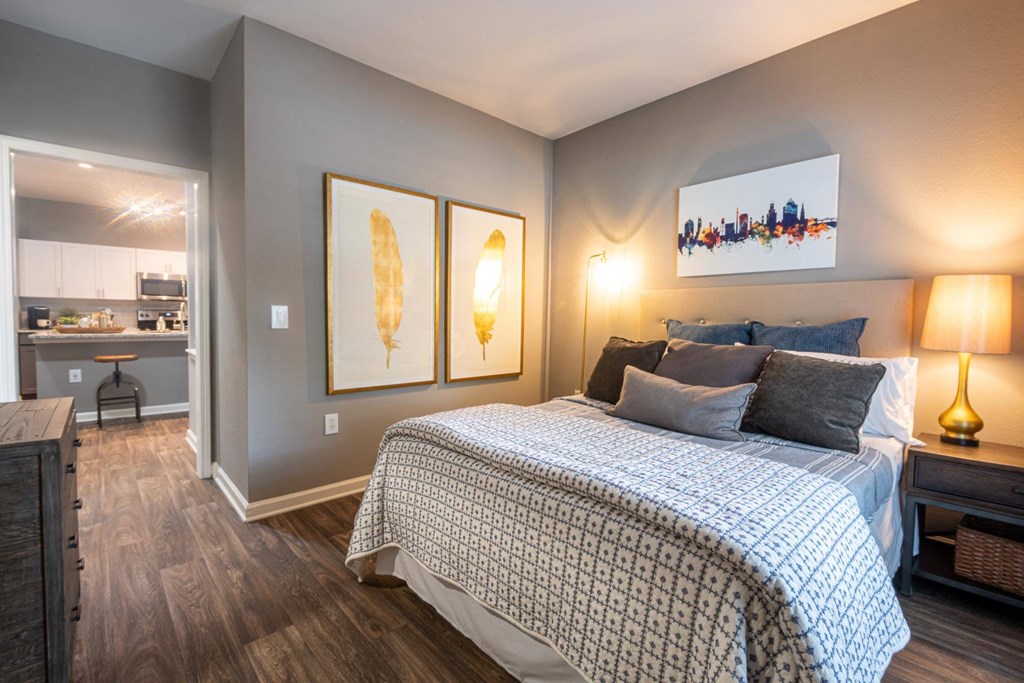 a bedroom with a bed and two paintings on the wall
