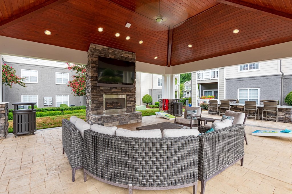 a covered patio with furniture and a fireplace
