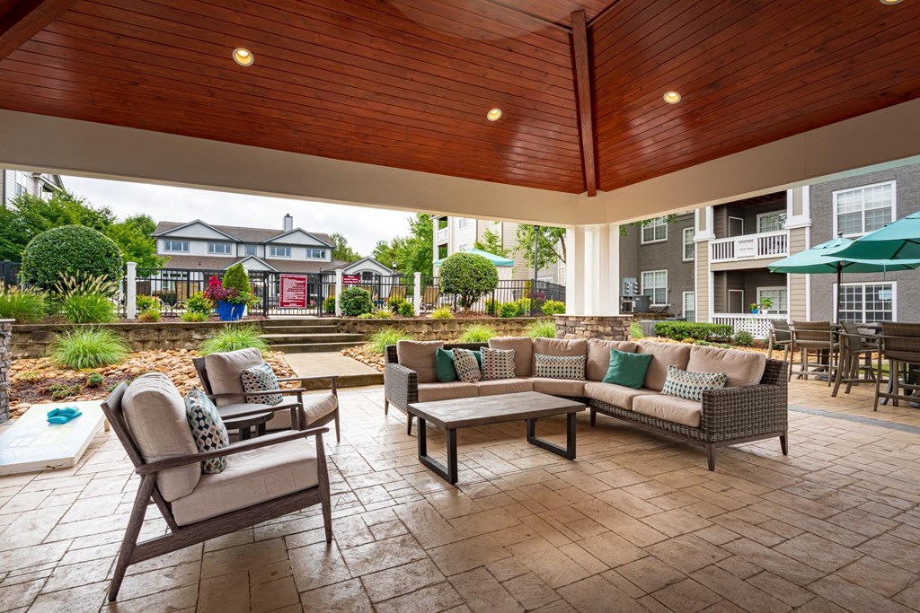 a covered patio with couches and chairs and tables