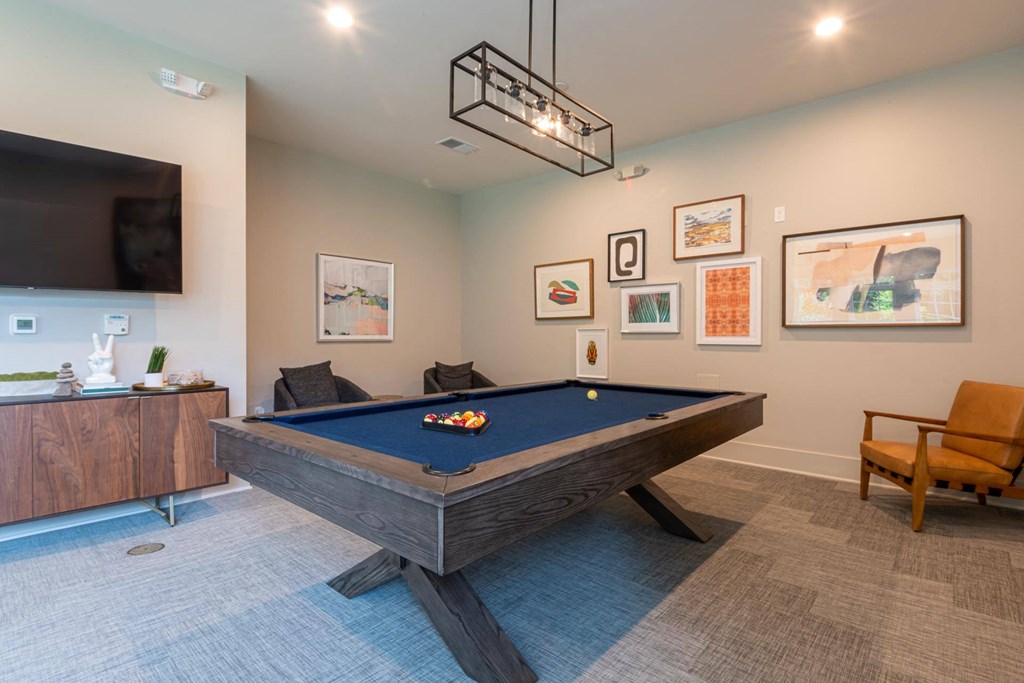 a games room with a pool table and a tv