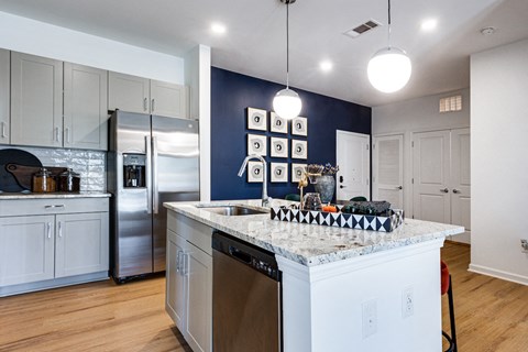 a kitchen with white cabinets and a marble counter top