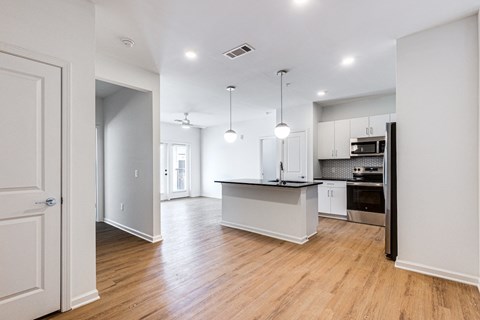 an empty kitchen and living room with white walls and wood floors