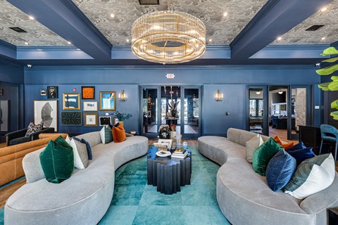 a living room with blue walls and couches and a chandelier