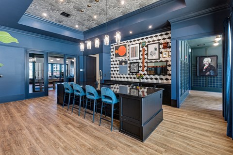 a bar with blue chairs and a counter in a room with blue walls and wood