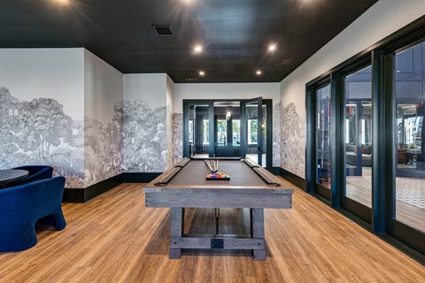 a games room with a shuffleboard table and a pool table