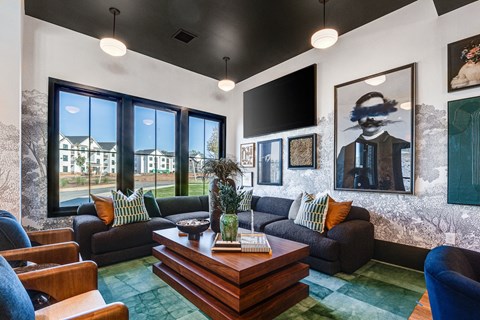 a living room with couches and a coffee table and large windows