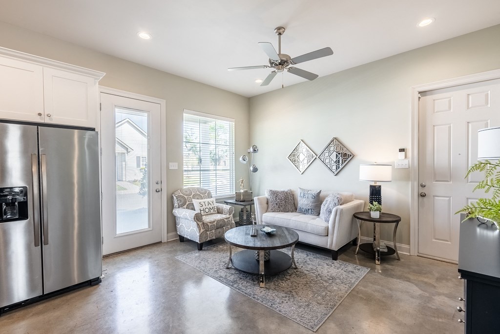 a kitchen and living room with a stainless steel refrigerator