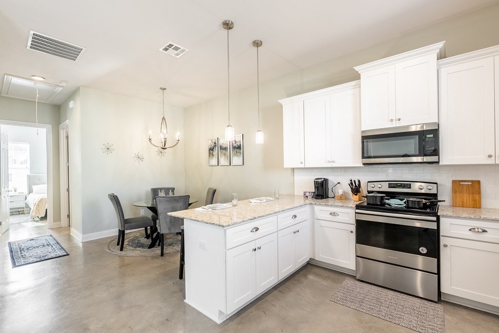 a kitchen with white cabinets and stainless steel appliances