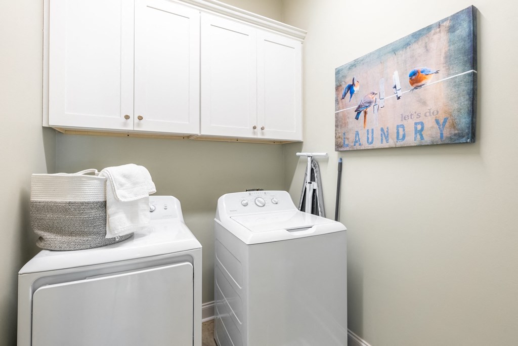 a washer and dryer in a laundry room with a painting on the wall