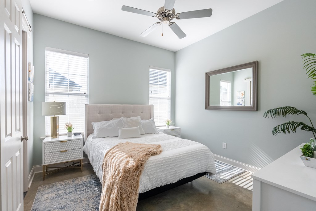 a bedroom with a large bed and a ceiling fan