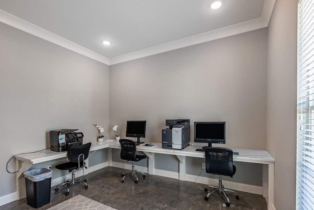 a home office with two desks and three computers