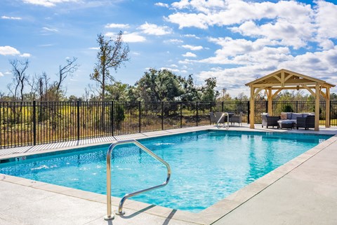 A pool with a slide and a gazebo.