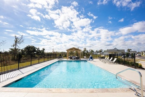 A large outdoor swimming pool surrounded by a black fence.