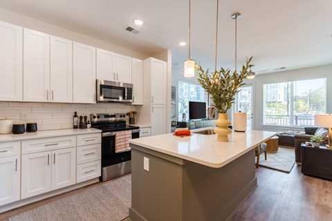 A modern kitchen with white cabinets and a large island.