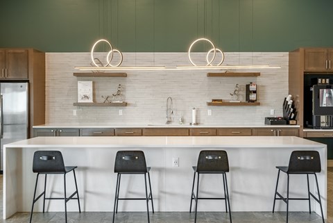 a kitchen with a counter and three stools