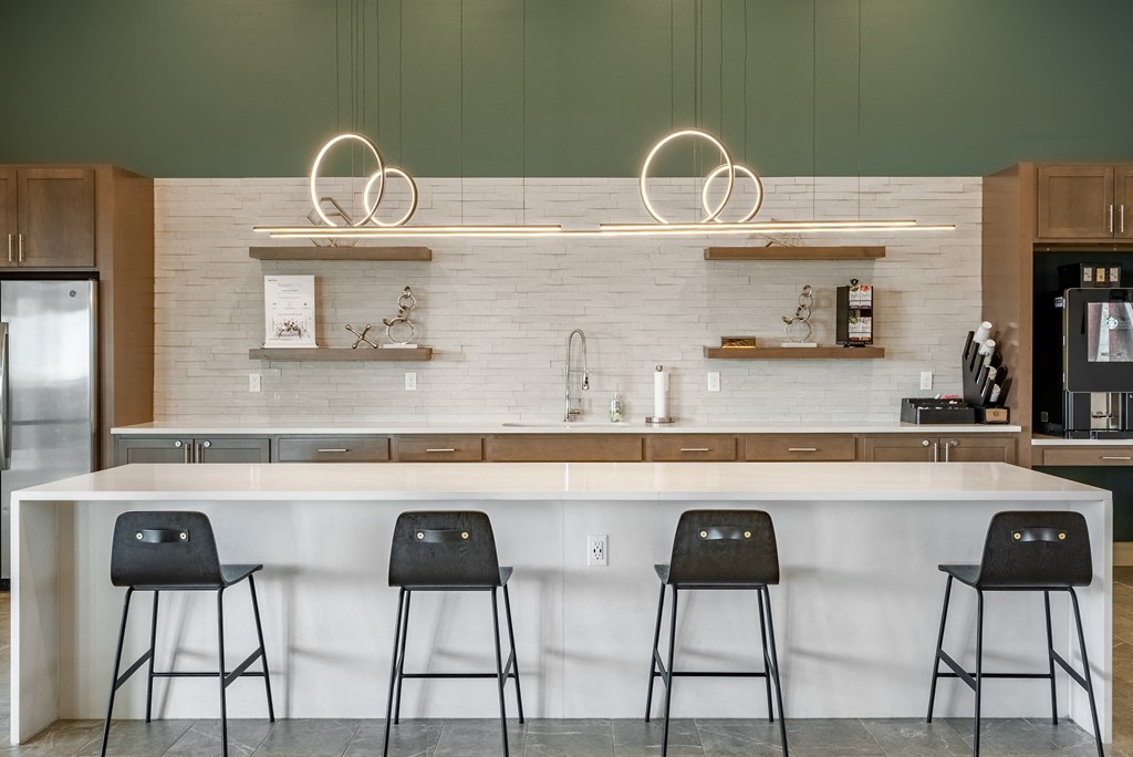 a kitchen with a counter and three stools