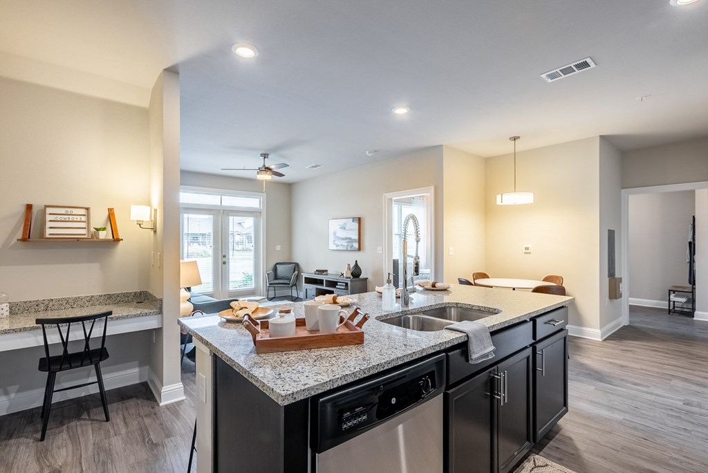 an open concept kitchen and living room with a large island with granite counter tops