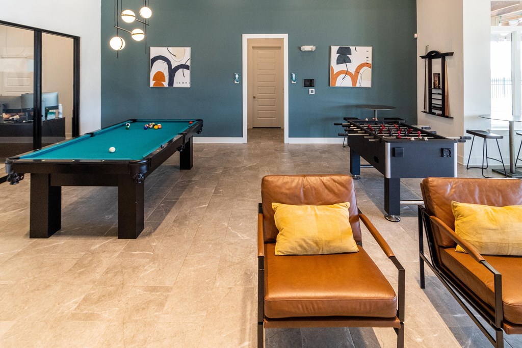 a billiards room with two pool tables and couches