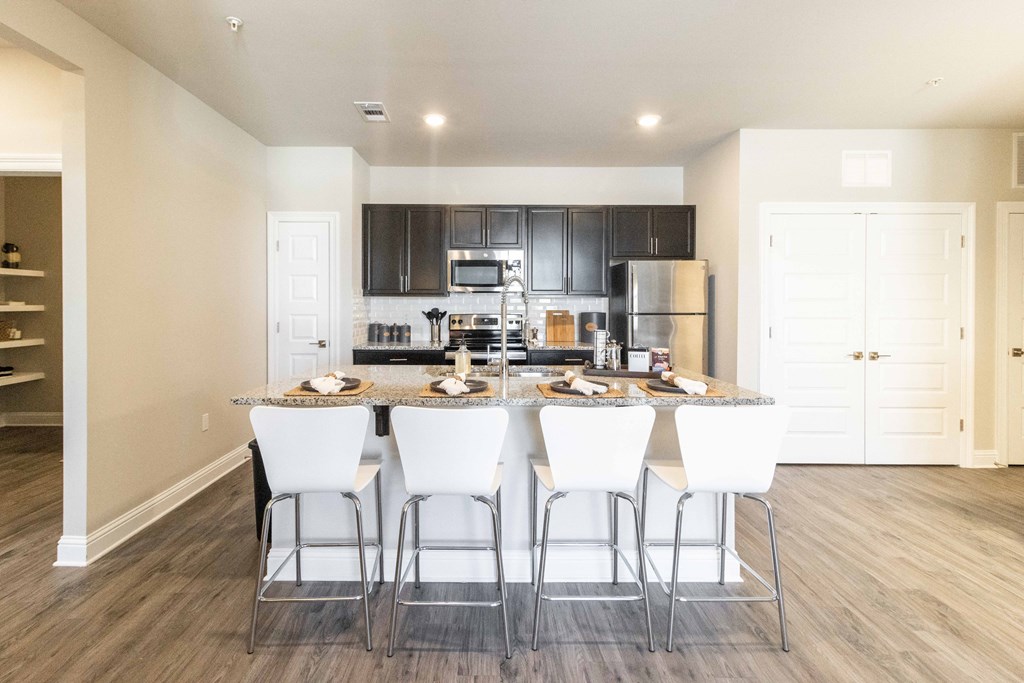 a kitchen and dining area with white chairs and a granite counter top