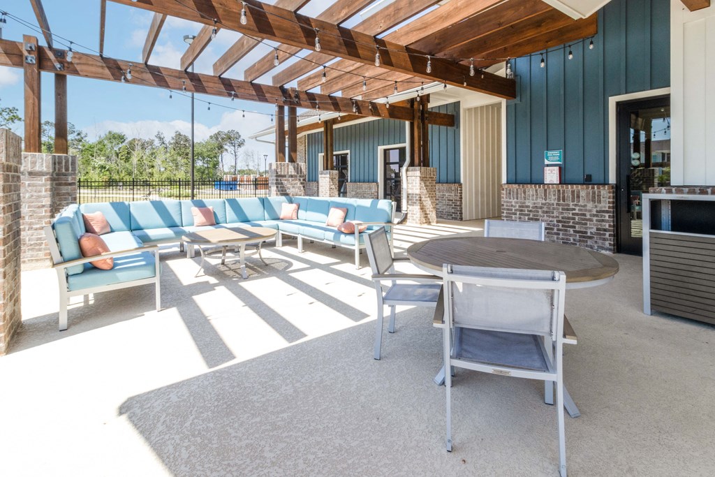 a covered patio with couches and chairs and a table