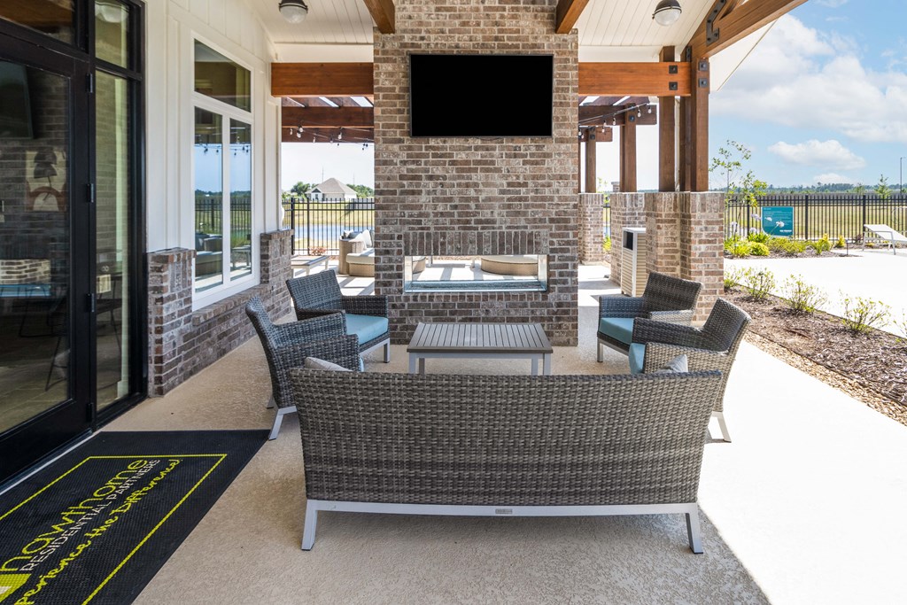 the outdoor seating area of a home with a fireplace and patio furniture