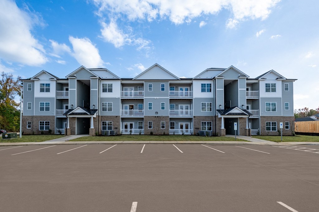 an empty parking lot in front of an apartment building