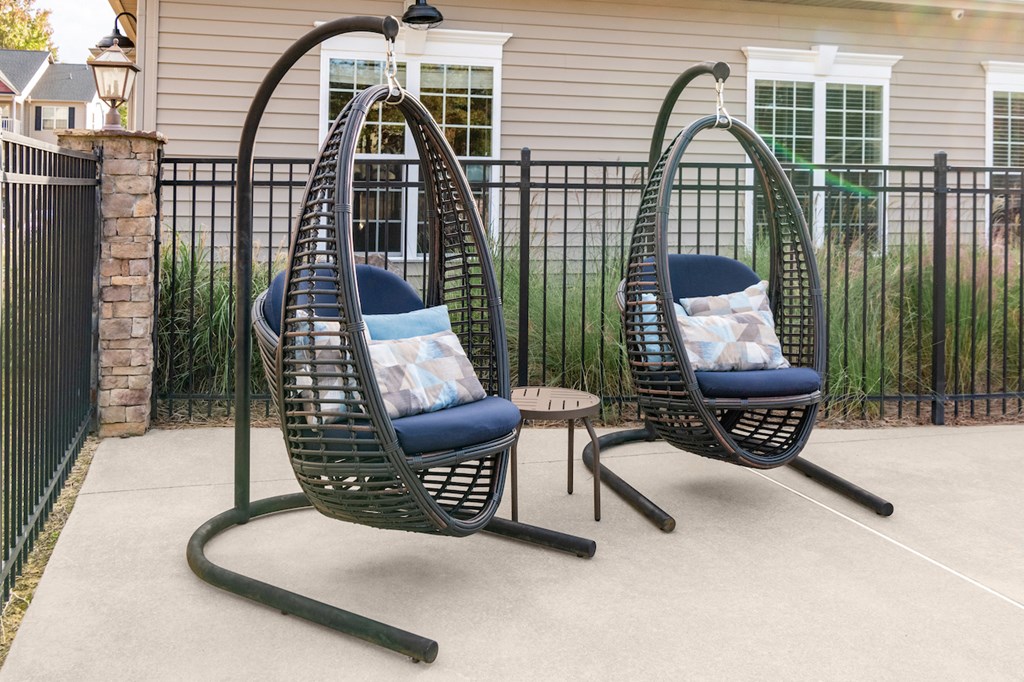 two swinging chairs on a porch in front of a house