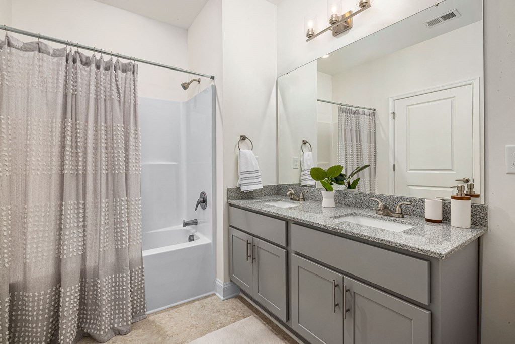 a bathroom with a shower and a sink and a mirror