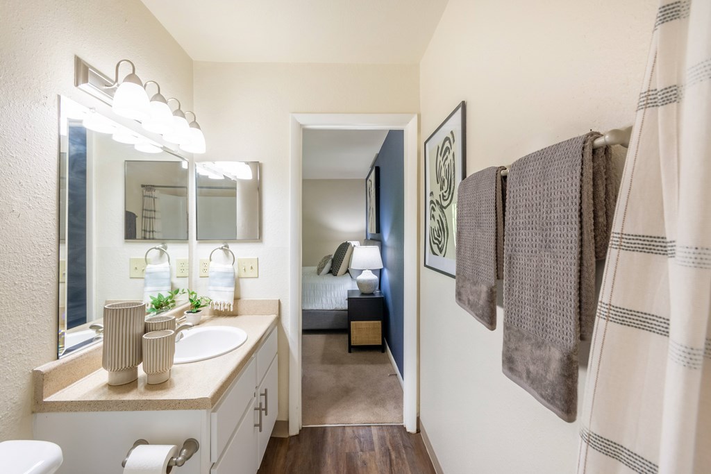 A bathroom with a white sink and a mirror above it at Hawthorne at Oak Ridge in Greensboro, NC.