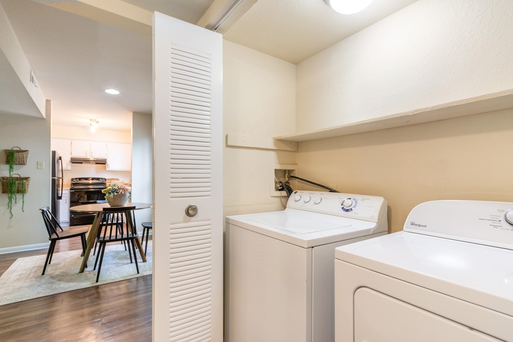 A white washing machine and dryer in a laundry room at Hawthorne at Oak Ridge in Greensboro, NC.