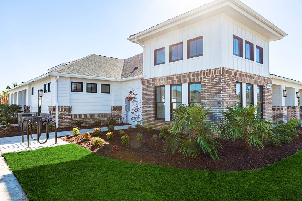 a view of the front of a house with a patio and grass