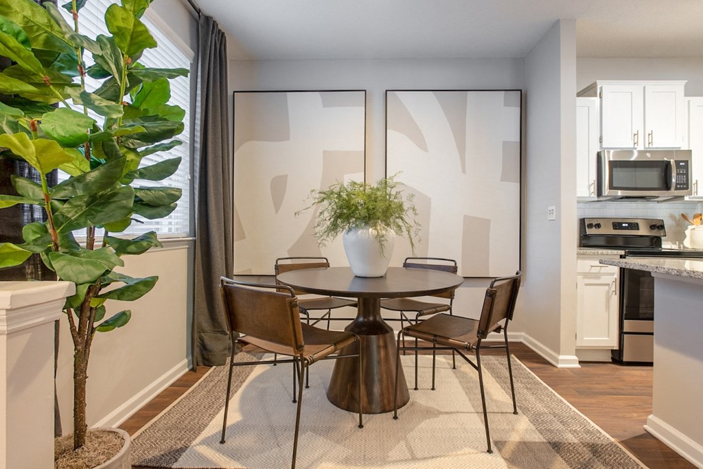 a dining room with a table and chairs and a plant