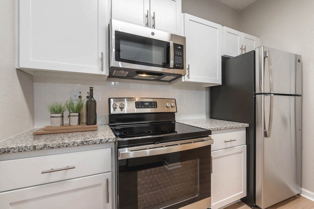 a kitchen with white cabinets and stainless steel appliances