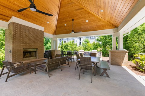 the screened porch has a fireplace and tables with chairs