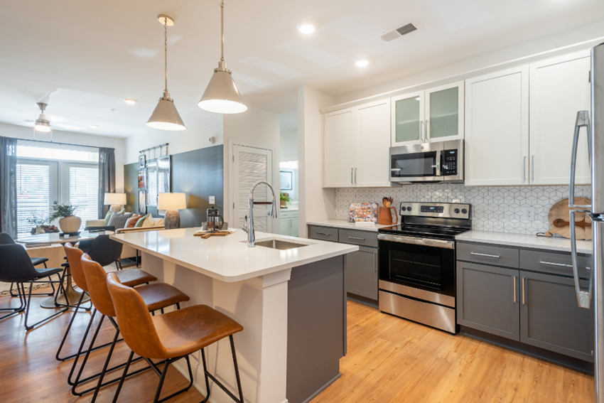 an open kitchen and living room with an island and chairs